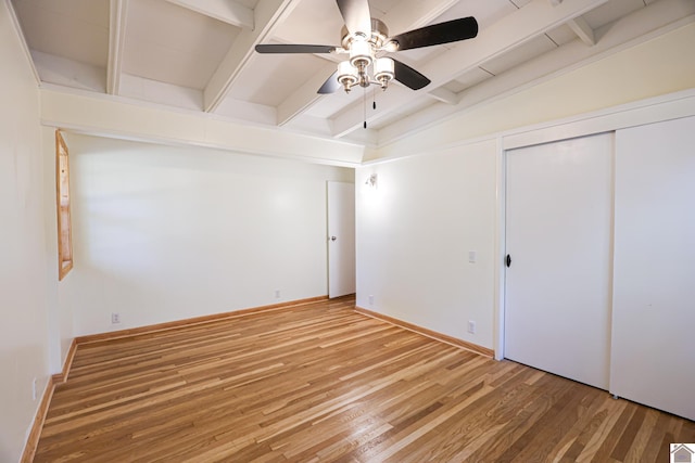 unfurnished bedroom with vaulted ceiling with beams, a closet, hardwood / wood-style flooring, and ceiling fan