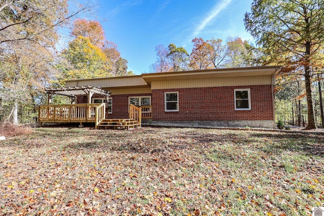 rear view of property with a wooden deck and a pergola