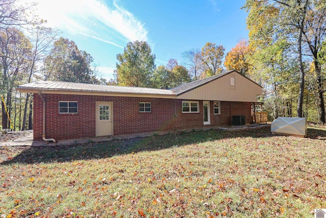 rear view of house with a lawn and central AC unit