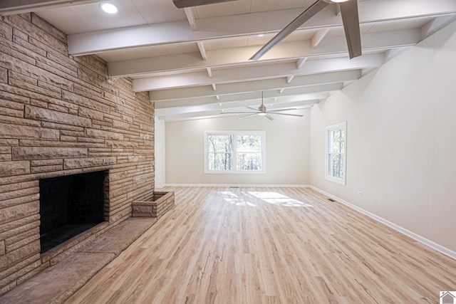 unfurnished living room with light hardwood / wood-style flooring, a fireplace, lofted ceiling with beams, and ceiling fan