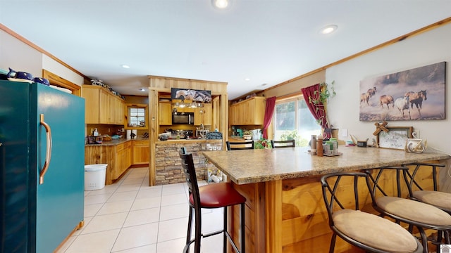 kitchen featuring light tile patterned floors, black appliances, kitchen peninsula, crown molding, and a breakfast bar area