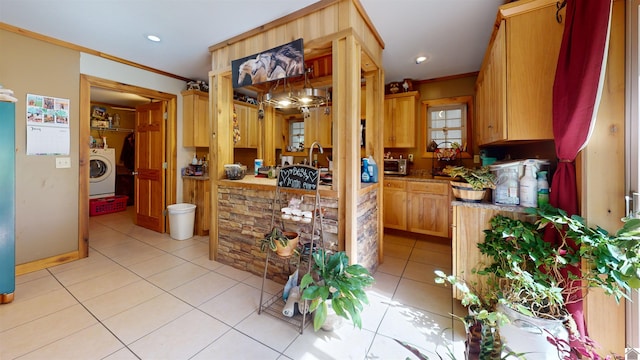 kitchen featuring ornamental molding, washer / clothes dryer, and light tile patterned floors