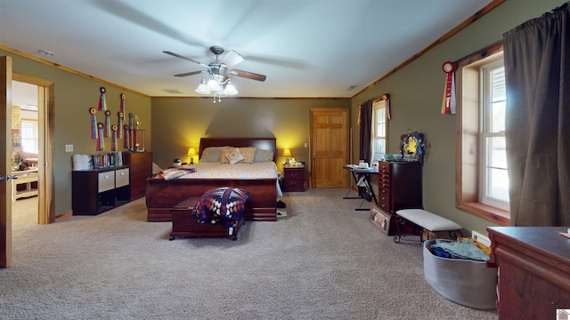 carpeted bedroom with ceiling fan, crown molding, and multiple windows