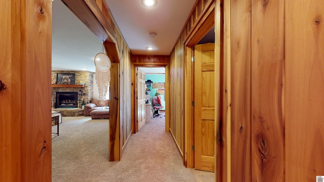 hall with light carpet and wood walls