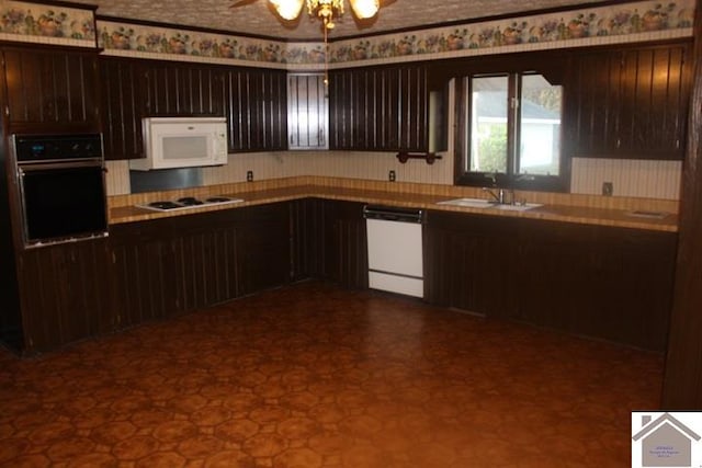 kitchen with white appliances, ceiling fan, dark brown cabinets, and sink