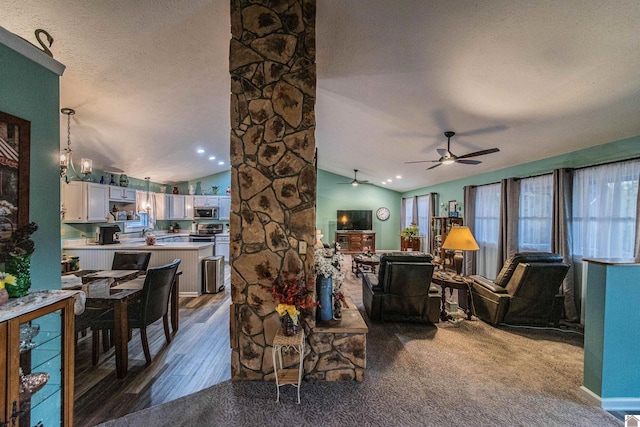 living room with vaulted ceiling, a textured ceiling, carpet floors, and ceiling fan