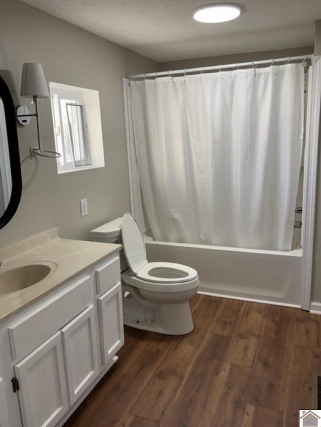 full bathroom featuring vanity, shower / tub combo with curtain, hardwood / wood-style flooring, and toilet