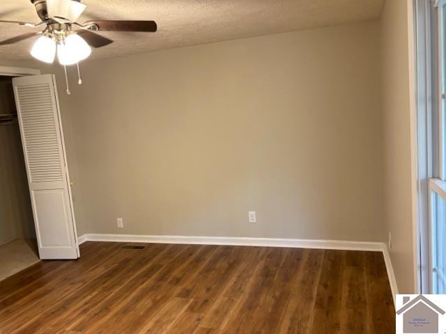 unfurnished bedroom featuring a closet, a textured ceiling, dark wood-type flooring, and ceiling fan