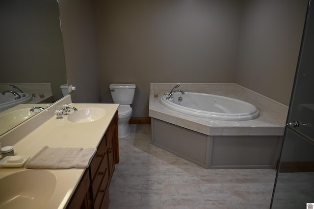 bathroom with vanity, a tub to relax in, and toilet