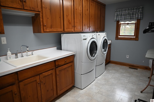 laundry area featuring sink, washer and dryer, and cabinets