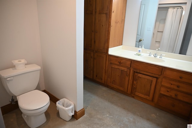 bathroom featuring concrete floors, vanity, and toilet