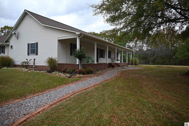 view of side of property featuring a porch and a lawn