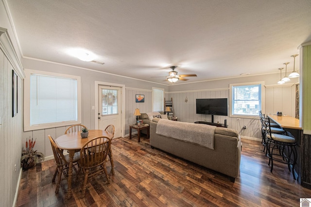 living room featuring ornamental molding, dark wood-type flooring, and ceiling fan