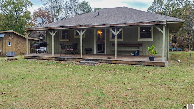 back of house featuring a storage shed, a wooden deck, a yard, and central AC unit