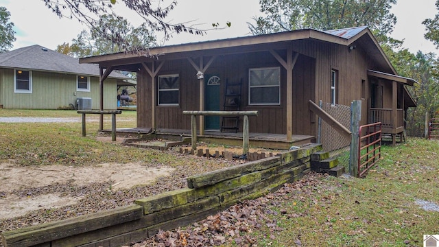 view of front of property with central AC unit, a front yard, and covered porch