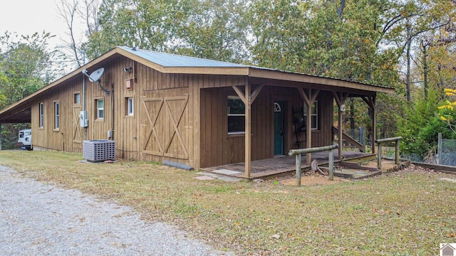 view of outbuilding featuring central AC unit and a yard