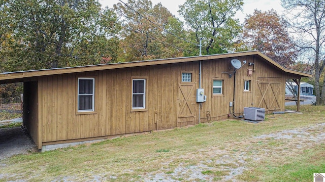 view of side of property with cooling unit and a yard