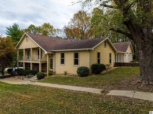 view of front of home with a front yard and a balcony