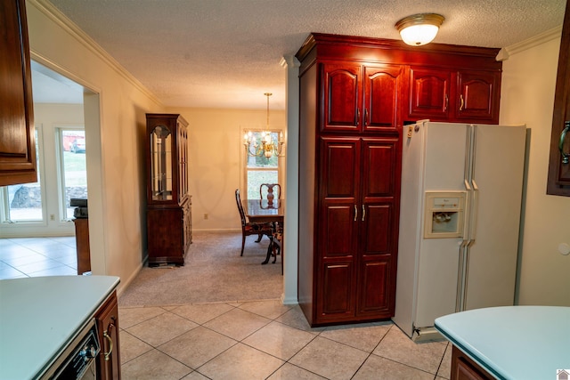 kitchen with a textured ceiling, ornamental molding, white fridge with ice dispenser, light tile patterned flooring, and decorative light fixtures