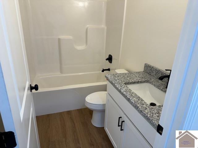 full bathroom with shower / washtub combination, hardwood / wood-style floors, vanity, and toilet