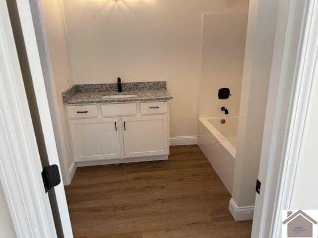 bathroom with shower / washtub combination, hardwood / wood-style floors, and vanity