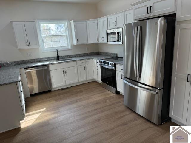 kitchen featuring light hardwood / wood-style floors, white cabinetry, sink, and appliances with stainless steel finishes