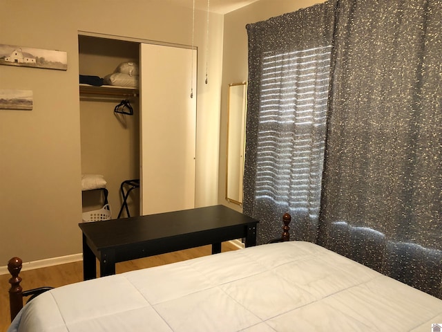 bedroom with wood-type flooring and a closet