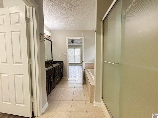 bathroom featuring shower with separate bathtub, vanity, a textured ceiling, and tile patterned floors