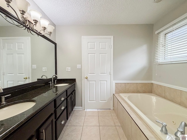 bathroom featuring a relaxing tiled tub, a textured ceiling, tile patterned floors, and vanity