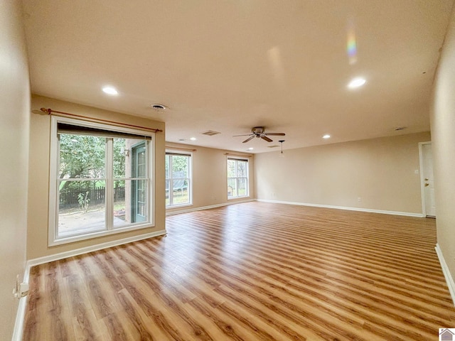 unfurnished living room with light wood-type flooring and ceiling fan