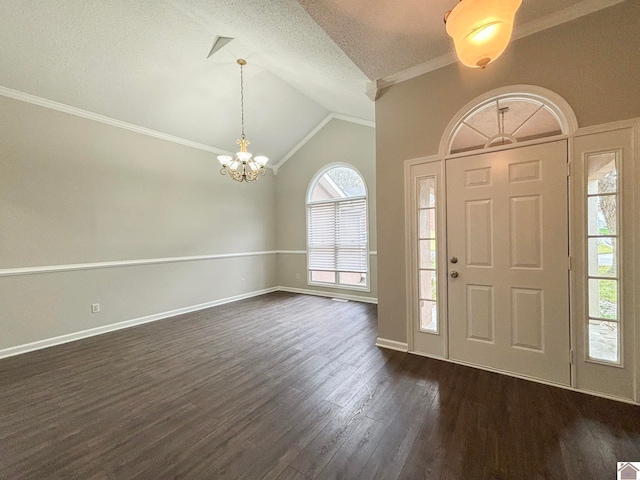 foyer featuring a textured ceiling, an inviting chandelier, crown molding, dark hardwood / wood-style flooring, and vaulted ceiling