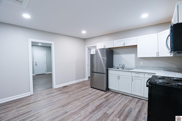 kitchen featuring white cabinets, light wood-type flooring, black appliances, and sink