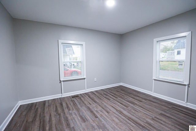 unfurnished room with dark wood-type flooring