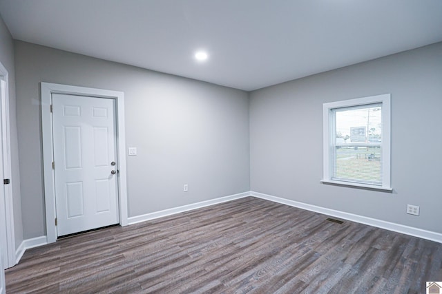 unfurnished room with dark wood-type flooring