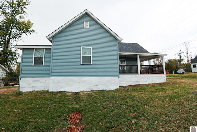 view of side of property with a lawn and covered porch