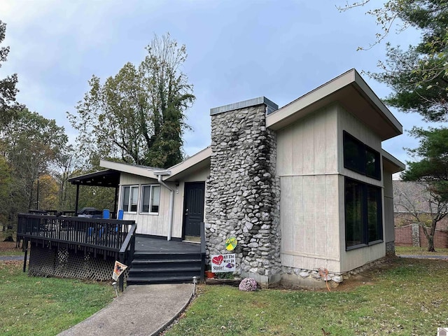 view of front of house featuring a front yard and a deck