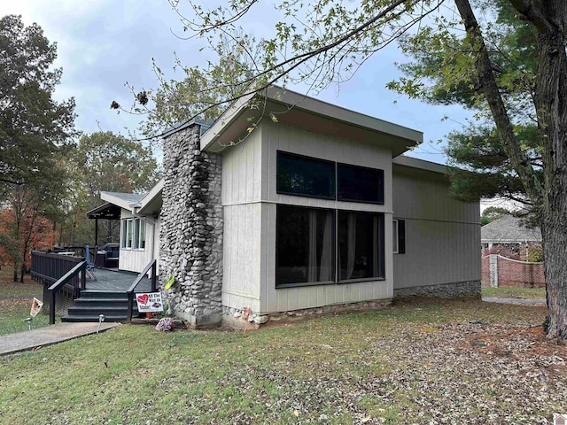 view of property exterior featuring a yard and a deck