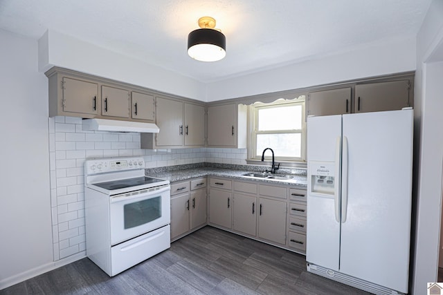 kitchen featuring white appliances, a sink, under cabinet range hood, and gray cabinetry