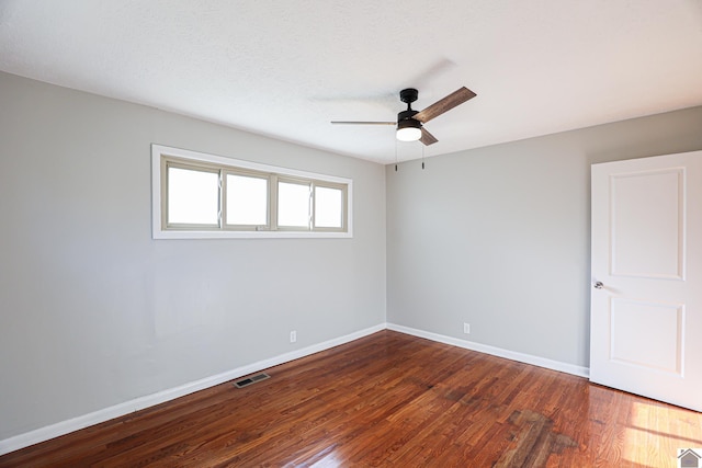 unfurnished room featuring ceiling fan, a textured ceiling, wood finished floors, visible vents, and baseboards