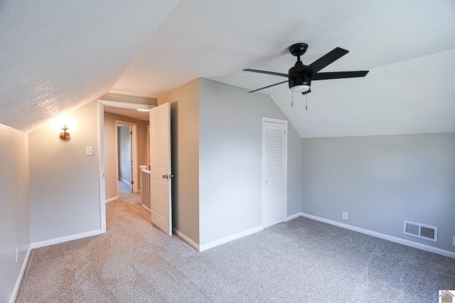 bonus room with light carpet, visible vents, a textured ceiling, and baseboards