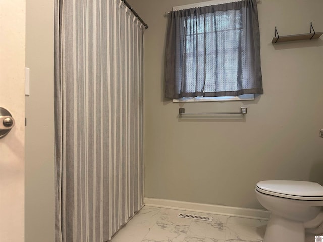 bathroom with curtained shower and toilet