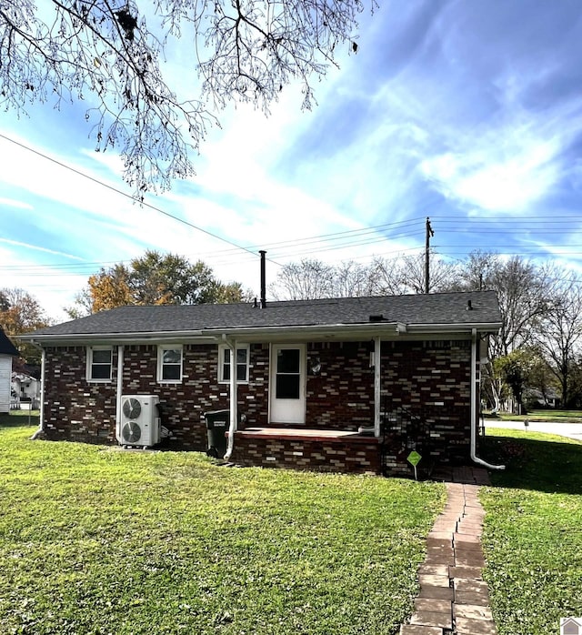 rear view of house with ac unit and a yard