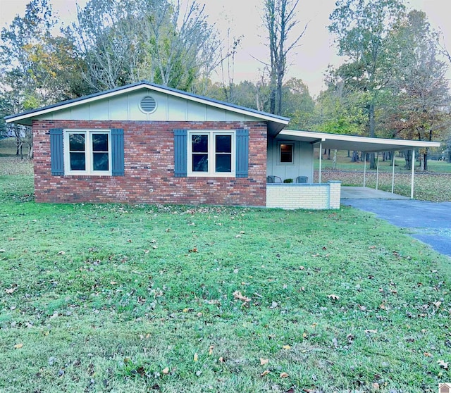 single story home featuring a front lawn and a carport