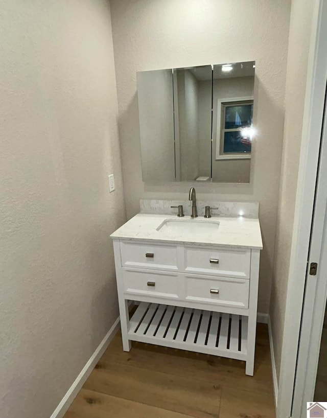 bathroom with hardwood / wood-style floors and vanity