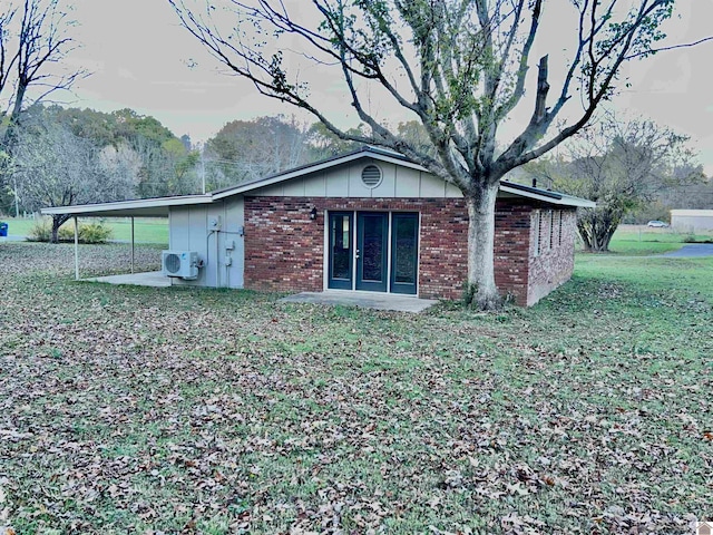 back of house featuring ac unit, a lawn, and a carport