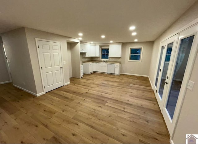 kitchen with white cabinets, french doors, light hardwood / wood-style flooring, and white dishwasher