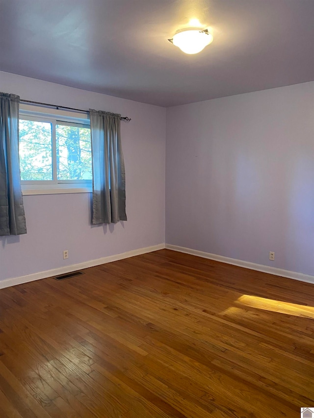 unfurnished room with dark hardwood / wood-style floors