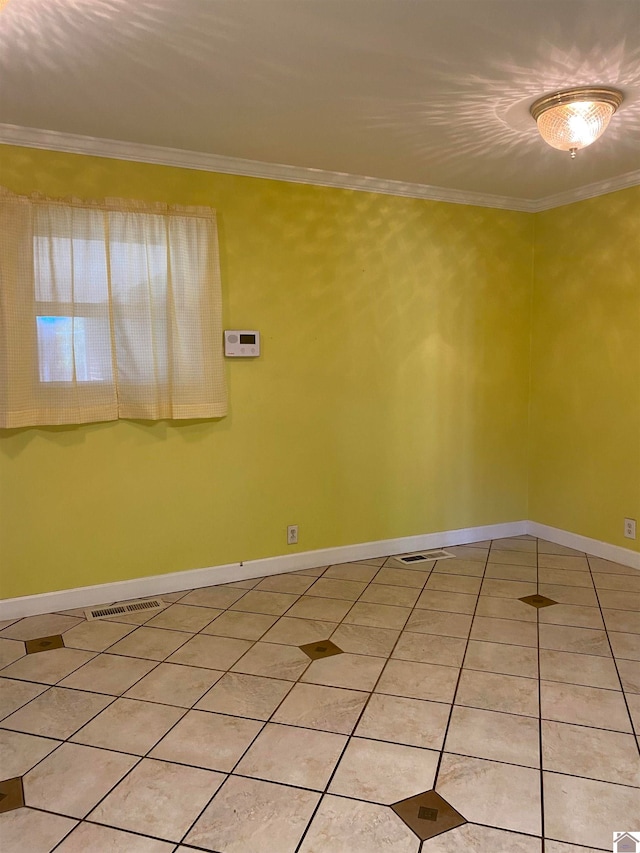 spare room featuring tile patterned flooring and ornamental molding