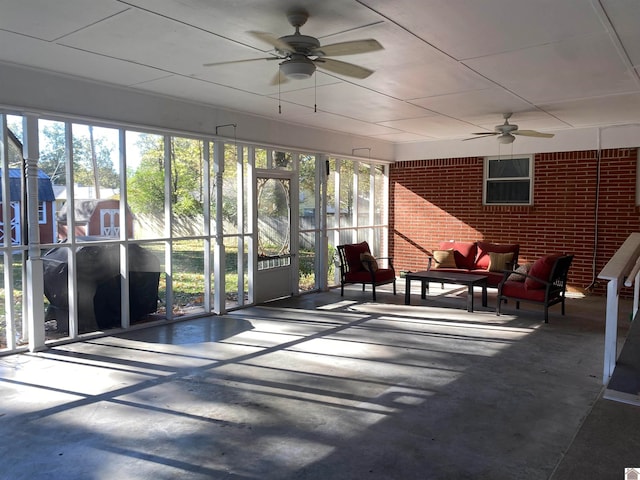 unfurnished sunroom featuring ceiling fan