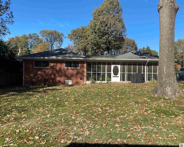 back of house with a lawn and a sunroom